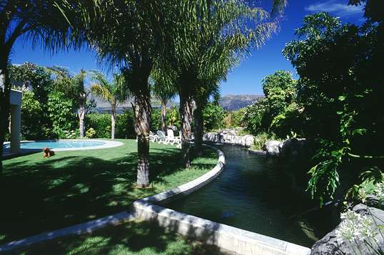 Der Pool, Palmen und Wasserspiele